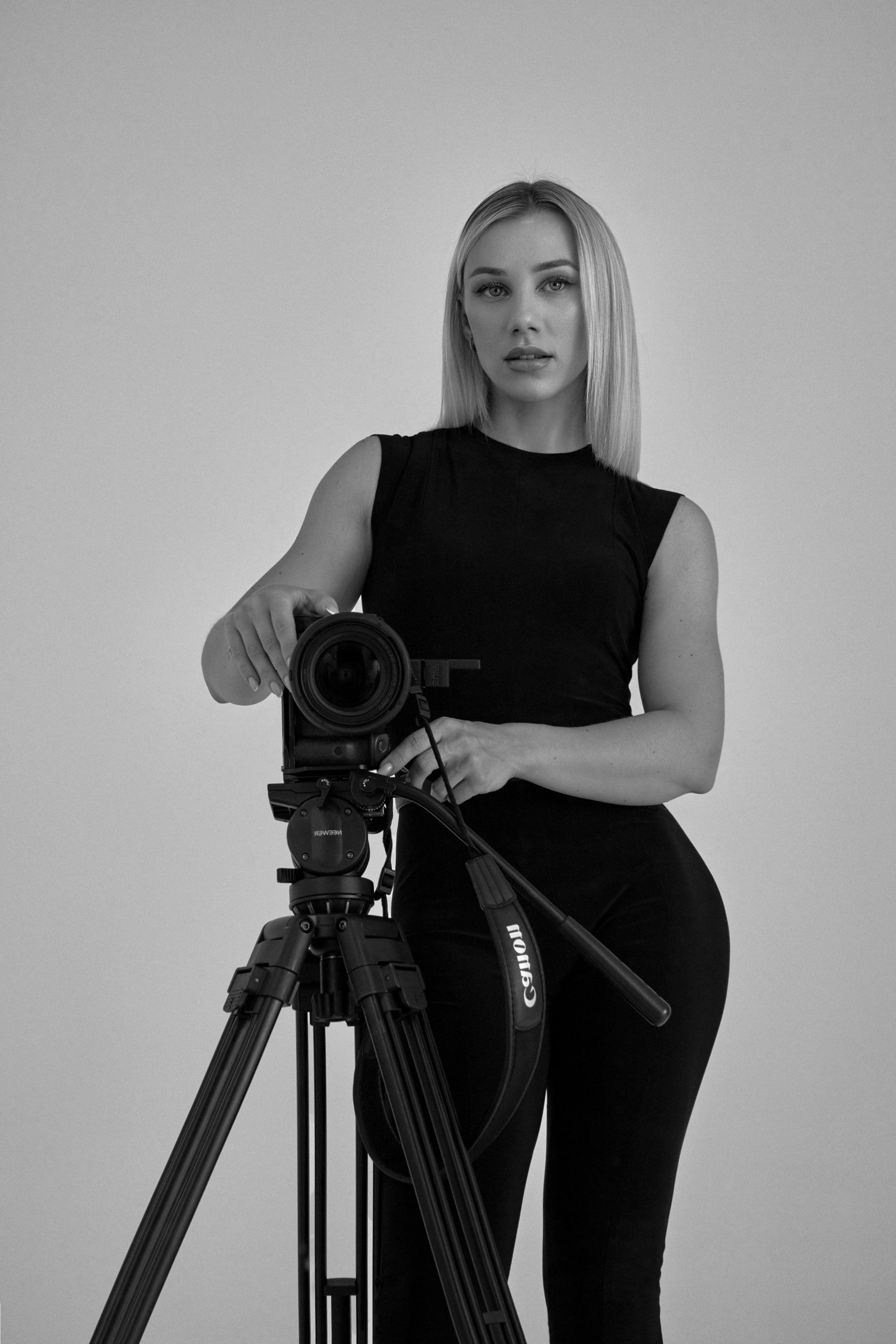 Irma Lion standing beside a camera on a tripod